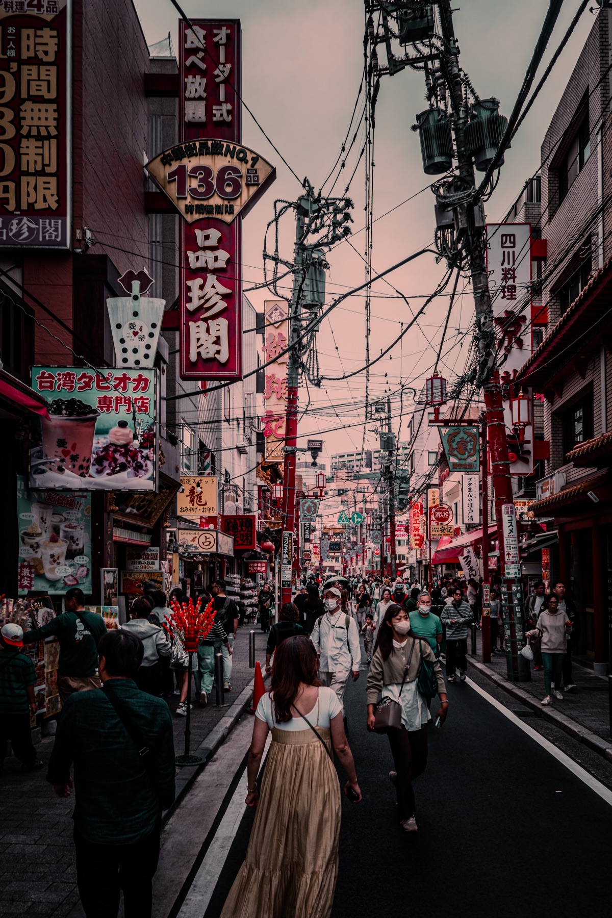 A busy Japan street filled with layered storefront signs and overhead wires.