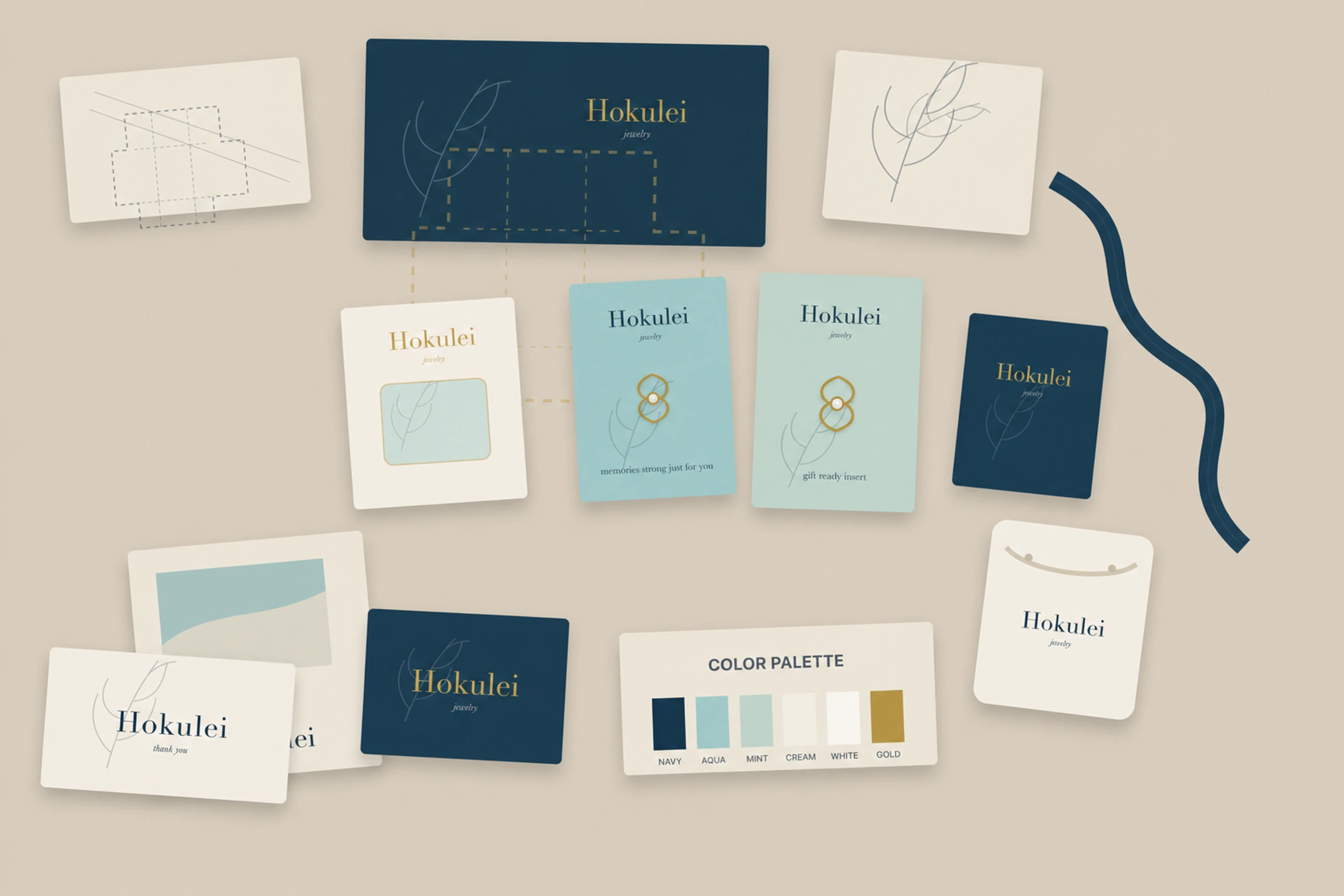 Hoku Lei packaging process table with dielines, windowed box prototypes, insert cards, tissue, paper swatches, ribbon, and jewelry.