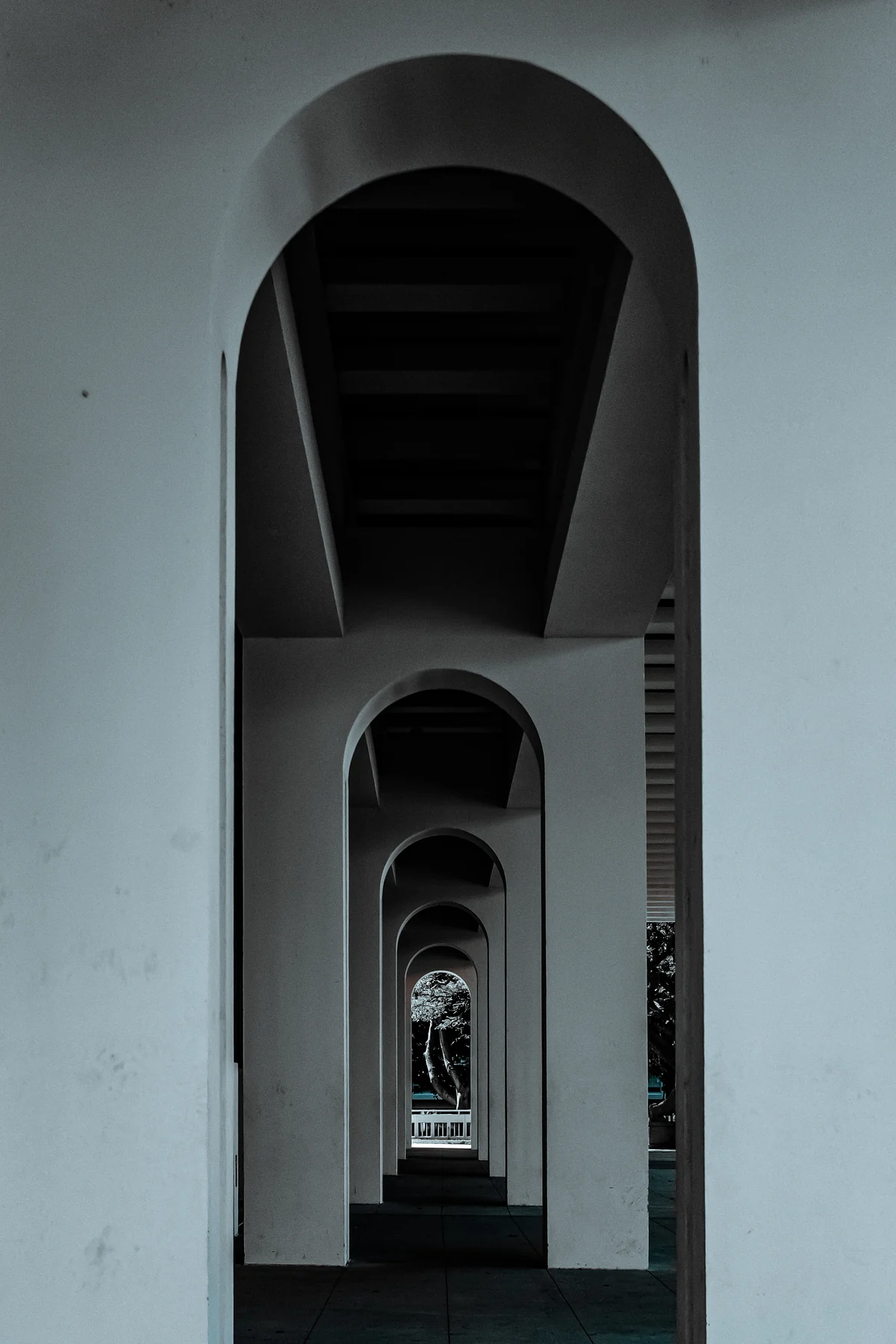 A repeating series of white arches receding into shadow.