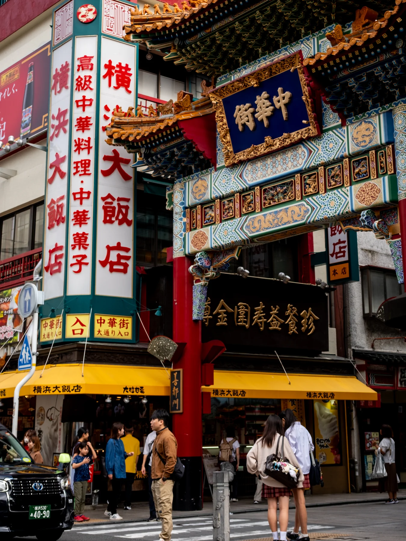 A richly detailed Chinatown storefront framed by signs and pedestrians.