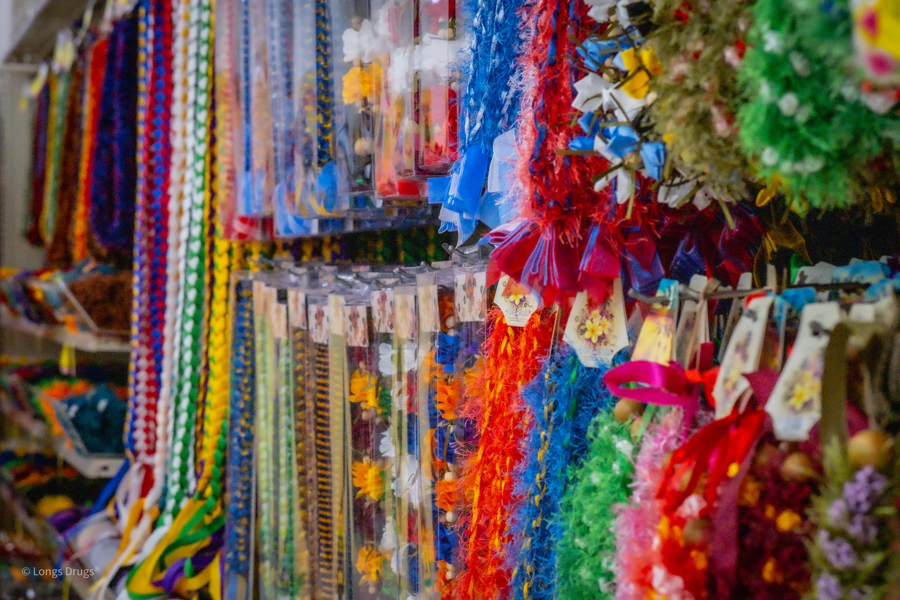 Rows of colorful lei and craft materials filling a store display.